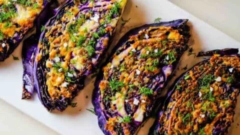 Roasted red cabbage steaks topped with garlic and parmesan cheese