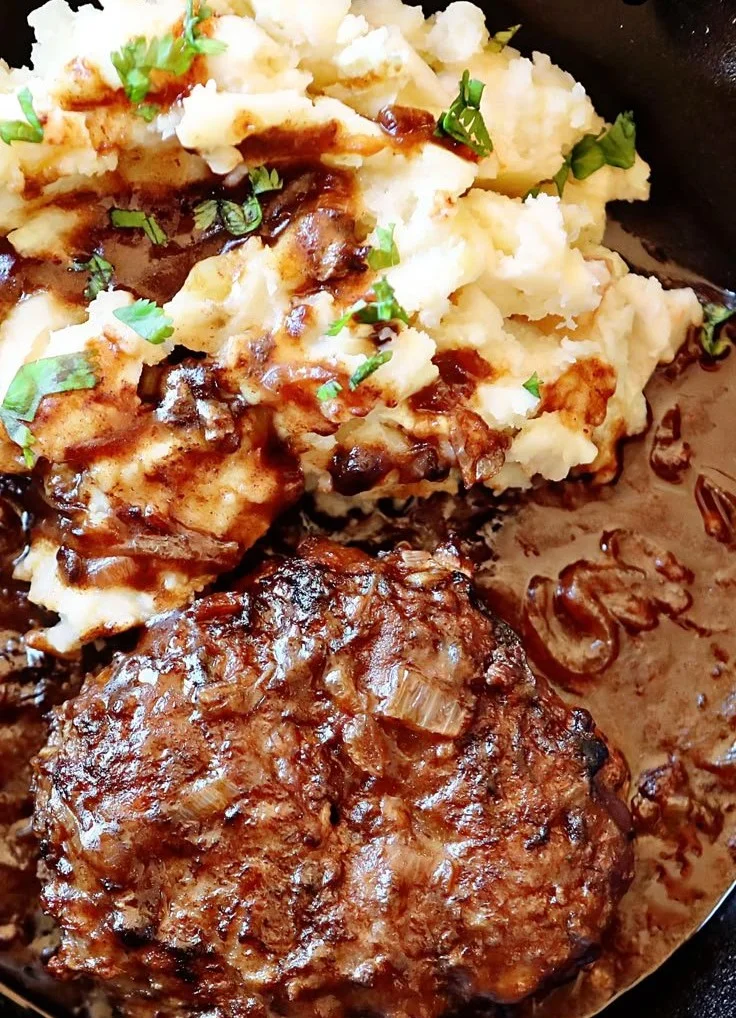 Delicious Salisbury Steak served with gravy and sides on a plate