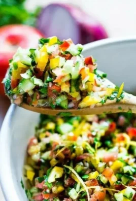 Fresh ingredients in a simple healthy Israeli salad, topped with herbs and olive oil.