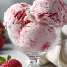 Delicious strawberry cottage cheese ice cream in a bowl with fresh strawberries.