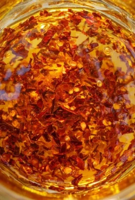Jar of sweet homemade hot honey with chili peppers in a rustic kitchen