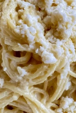 Plate of White Spaghetti garnished with fresh herbs and cheese
