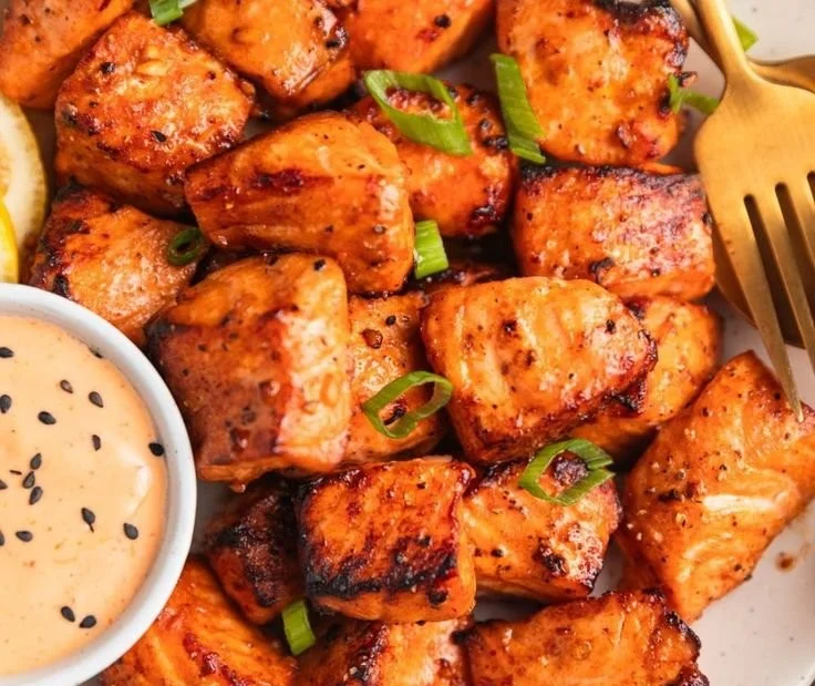 Air fryer salmon bites with Bang Bang sauce on a plate