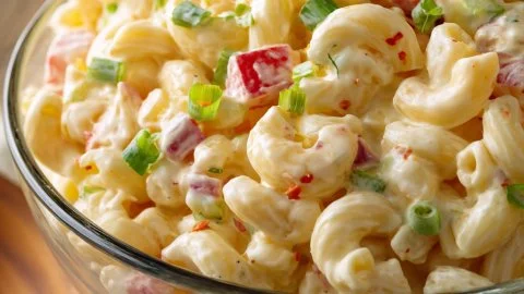 Delicious Amish Macaroni Salad served in a bowl with vegetables and dressing.