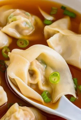 Delicious bowl of wonton soup with fresh ingredients and herbs