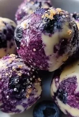 Blueberry cheesecake bites topped with fresh blueberries on a white plate