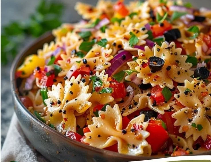 Colorful bow tie pasta salad with fresh vegetables and dressing