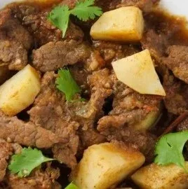Delicious plate of braised beef garnished with herbs and served with vegetables