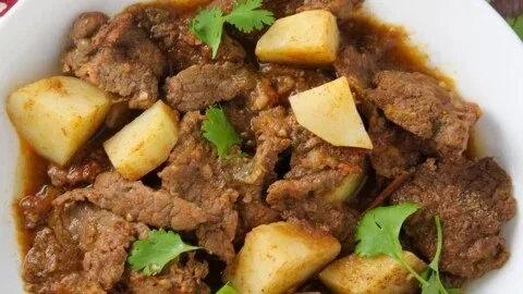 Delicious plate of braised beef garnished with herbs and served with vegetables