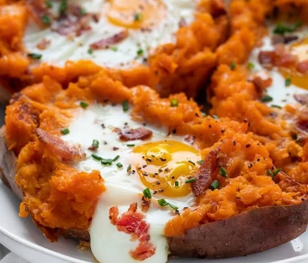 Healthy Breakfast Sweet Potato dish topped with eggs and herbs