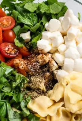 Caprese Salad with Tortellini featuring tomatoes, mozzarella, and fresh basil