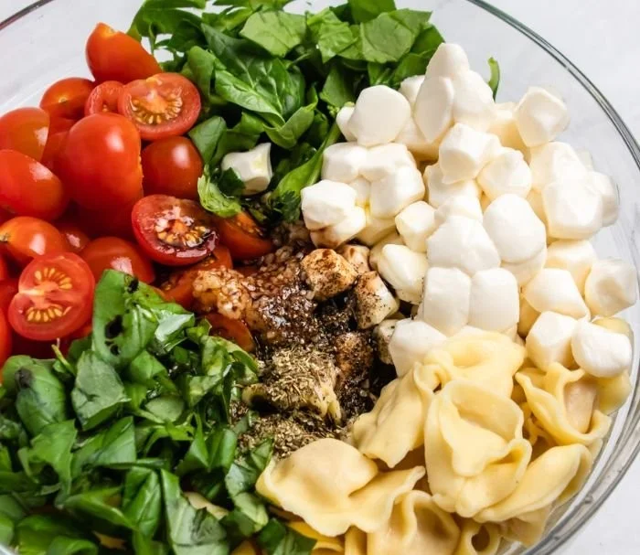 Caprese Salad with Tortellini featuring tomatoes, mozzarella, and fresh basil