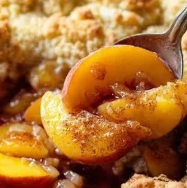Delicious cast iron peach cobbler with golden crust and fresh peaches