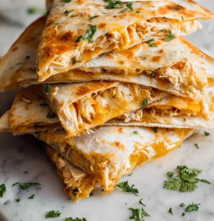 Plate of cheesy Chicken Quesadillas with grilled chicken and fresh toppings
