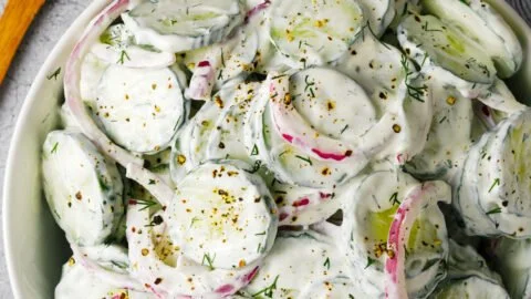 Creamy cucumber salad served in a bowl with fresh herbs and spices