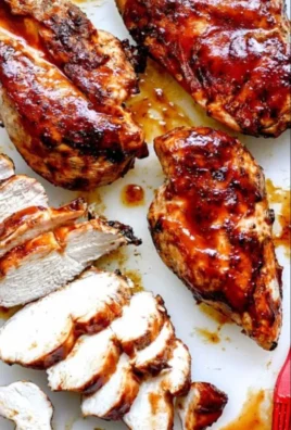 Juicy BBQ chicken on a grill with barbecue sauce glistening