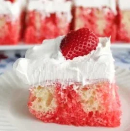 Delicious Easy Strawberry Poke Cake topped with fresh strawberries and cream