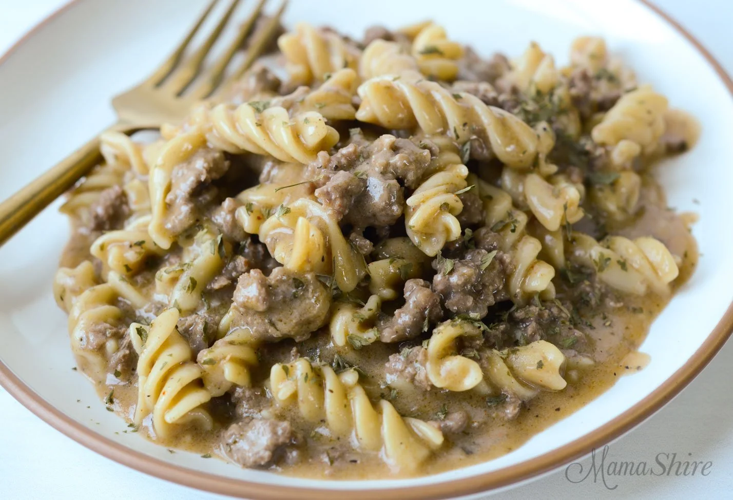 Gluten-free dairy-free beef stroganoff served in a bowl with herbs on top