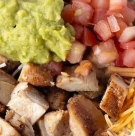 Grilled Chicken Burrito Bowl with rice and beans garnished with fresh ingredients
