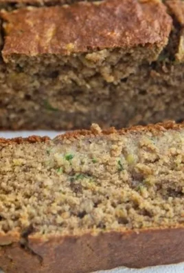 A delicious slice of healthy oatmeal zucchini banana bread on a wooden cutting board.