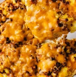 High protein sausage and egg breakfast pizza topped with cheese and herbs.