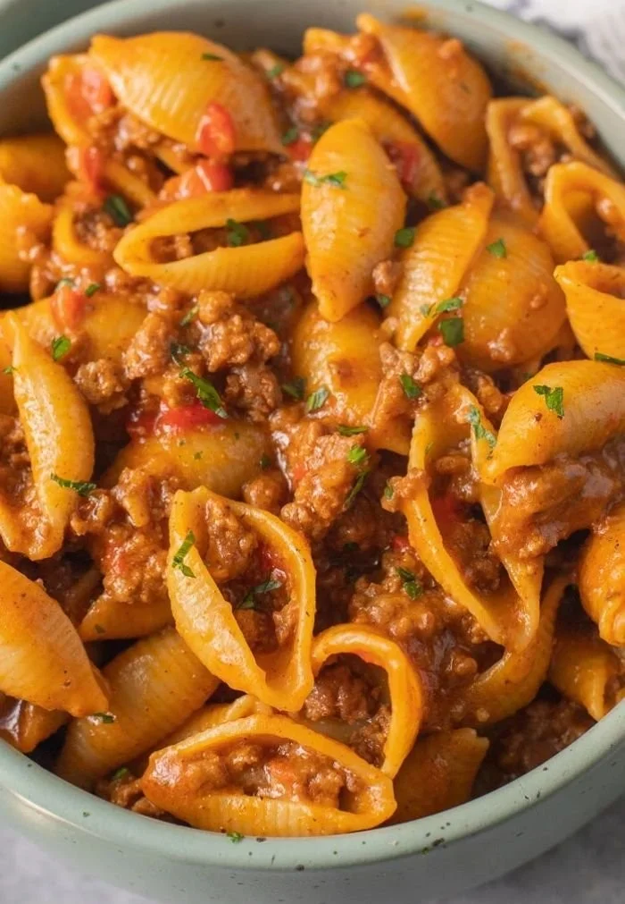 High protein taco pasta dish topped with fresh herbs and cheese