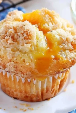 Plateful of freshly baked homemade peach cobbler muffins topped with crumble.