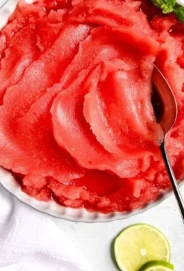 Bowl of homemade watermelon sorbet served with fresh mint leaves