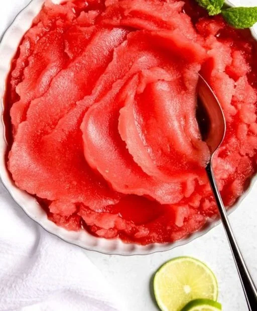Bowl of homemade watermelon sorbet served with fresh mint leaves