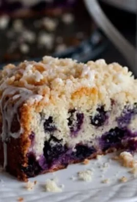 Lemon Blueberry Coffee Cake slice on a plate with fresh blueberries