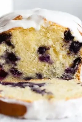 Slice of lemon blueberry pound cake topped with fresh blueberries