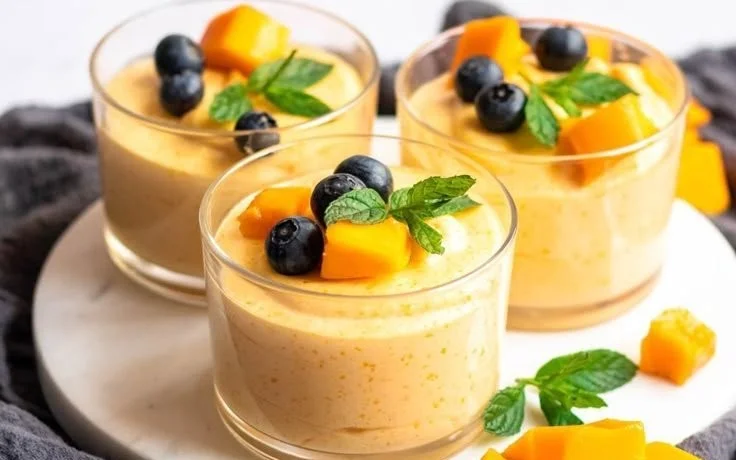 Delicious Mango Mousse dessert served in a glass with fresh mango slices