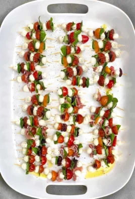 Mini Caprese Salad Skewers with tomatoes, mozzarella, and basil on a platter