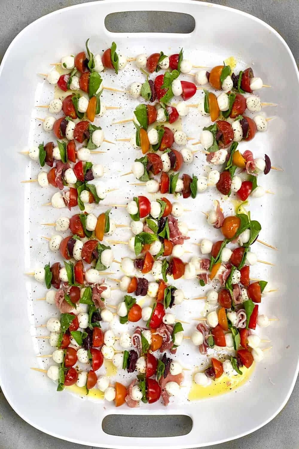 Mini Caprese Salad Skewers with tomatoes, mozzarella, and basil on a platter