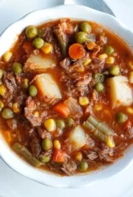 Bowl of my Mom's old-fashioned vegetable beef soup with fresh vegetables and beef