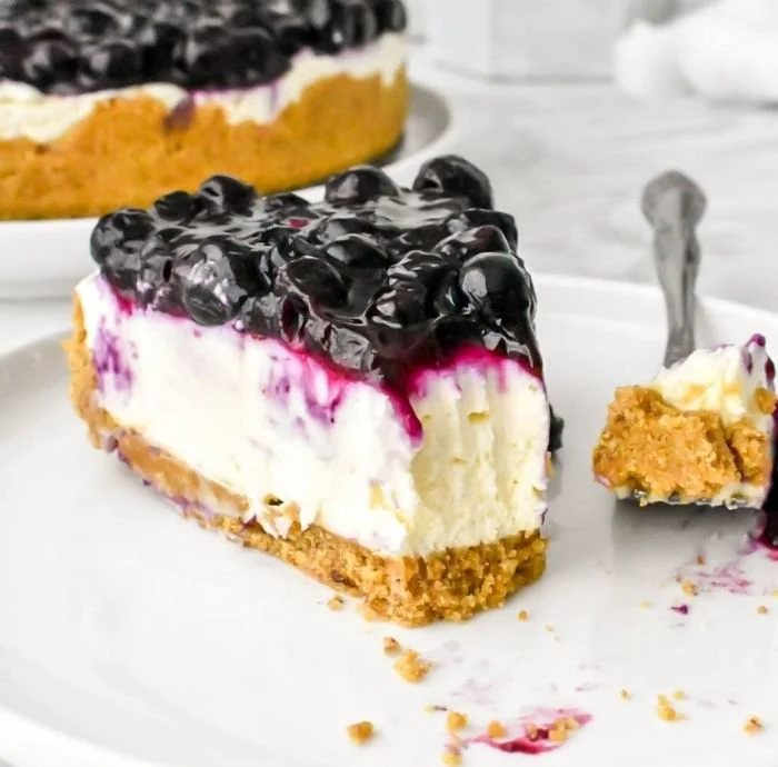 No bake blueberry cheesecake topped with fresh blueberries and whipped cream.