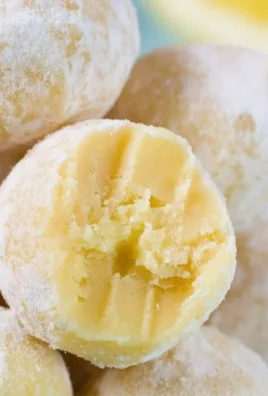 No bake lemon truffles topped with coconut flakes on a white plate