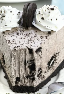 No-Bake Oreo Cheesecake topped with crushed Oreos and chocolate drizzle