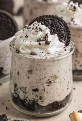 No bake Oreo cheesecake cups topped with crushed Oreo cookies.