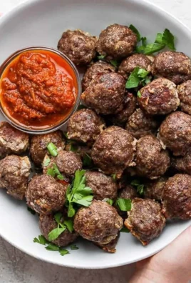 Oven baked meatballs on a platter garnished with parsley