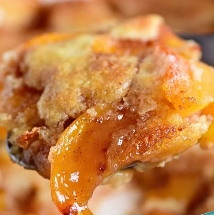 Delicious homemade Peach Cobbler served warm with a scoop of vanilla ice cream.