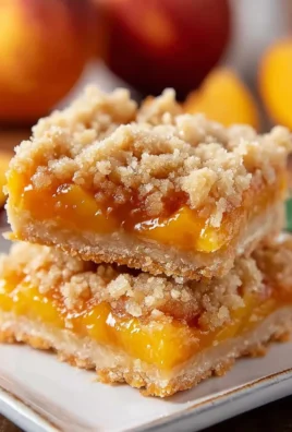 Delicious peach crumb bars topped with a golden crumb topping