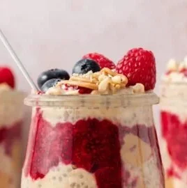 Peanut Butter and Jelly Overnight Oats in a glass jar with fresh strawberries
