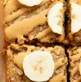Peanut Butter Banana Baked Oatmeal in a serving dish, topped with banana slices and peanut butter.