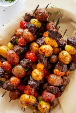 Grilled rosemary garlic steak kebabs on skewers, seasoned and ready to eat.