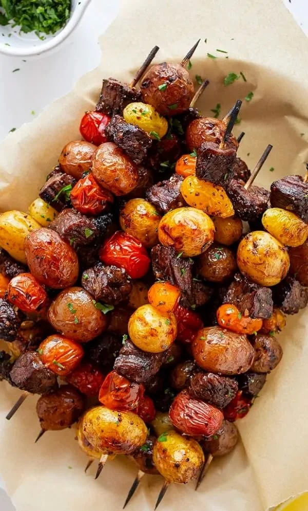 Grilled rosemary garlic steak kebabs on skewers, seasoned and ready to eat.