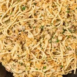 Sardine pasta topped with lemon and garlic crumbs in a bowl.