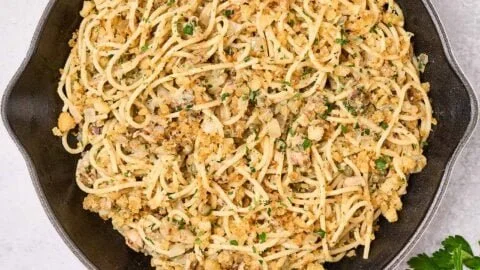 Sardine pasta topped with lemon and garlic crumbs in a bowl.
