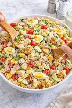 A colorful bowl of chef salad pasta salad with fresh vegetables and delicious dressing