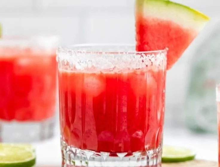 Skinny watermelon margarita served in a glass with lime garnish.